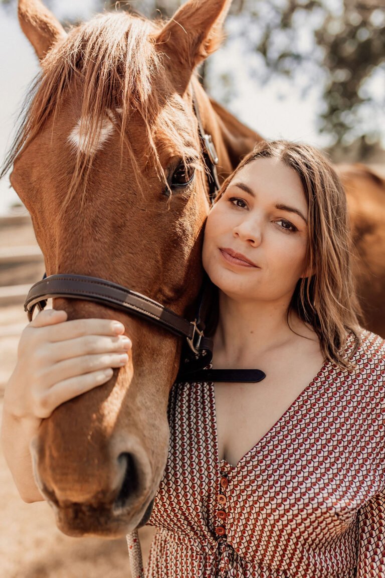 Brittany Birch standing calmly with a horse at Stable & Grounded.