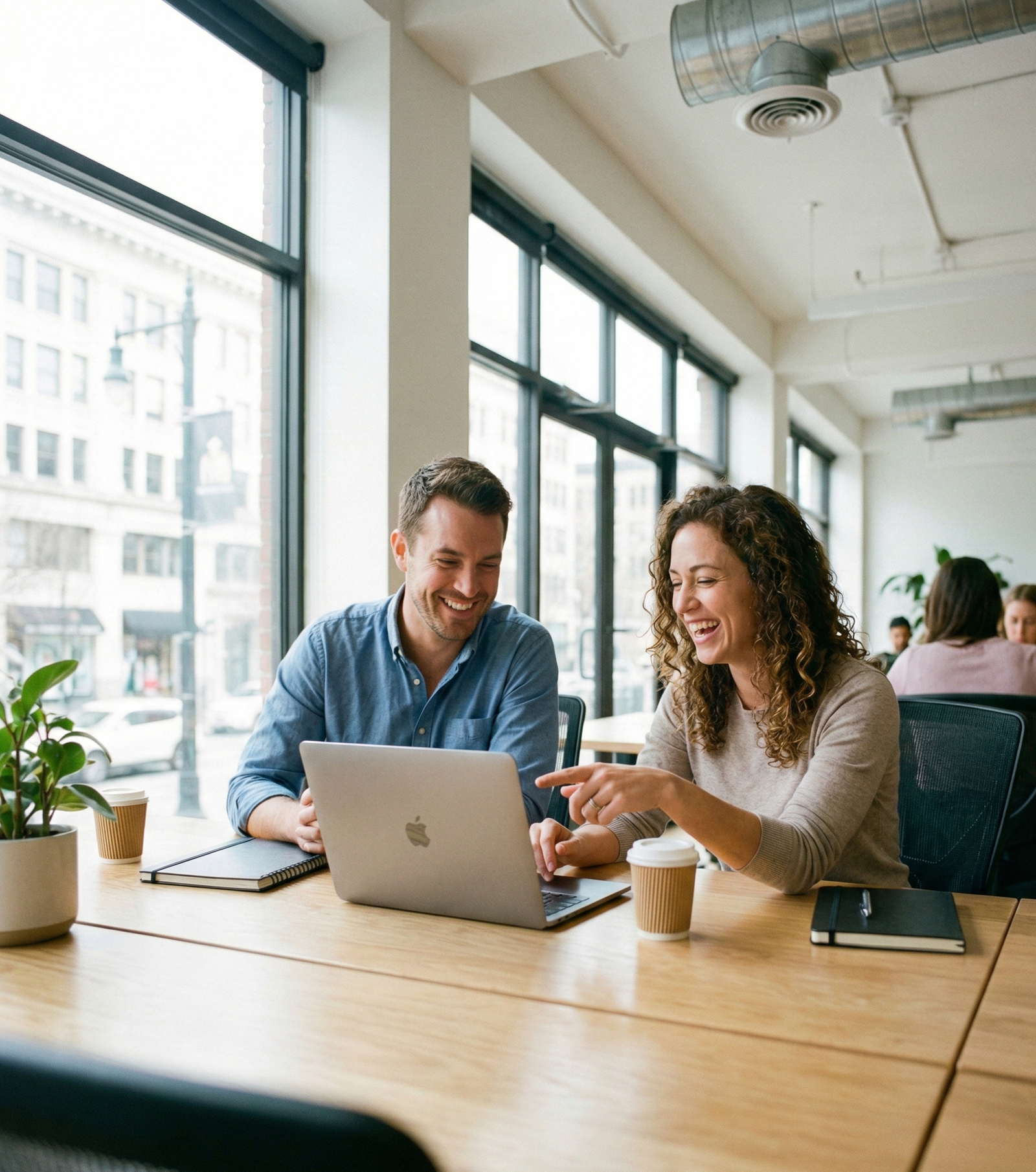 Two people smiling while working on a laptop indoors, symbolizing WorkReady Launchpad employment program, NDIS capacity building, and person‑centred career support services.